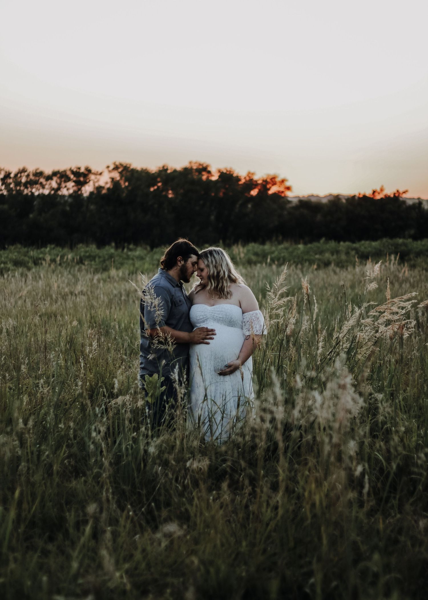 A couple shares tender moments in a wildflower field at sunset.
