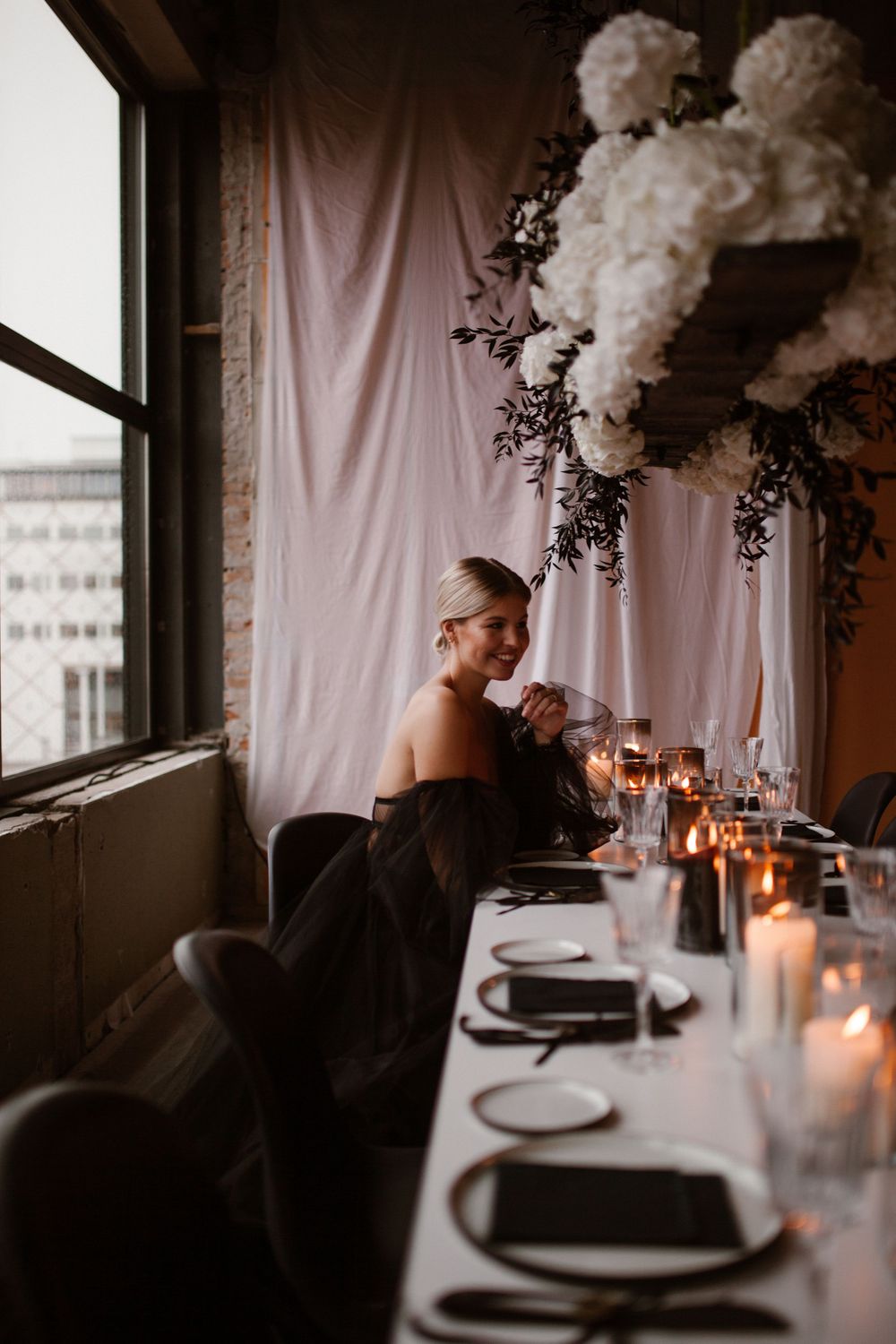 Romantic candlelit table setting with white floral centerpieces and place settings.
