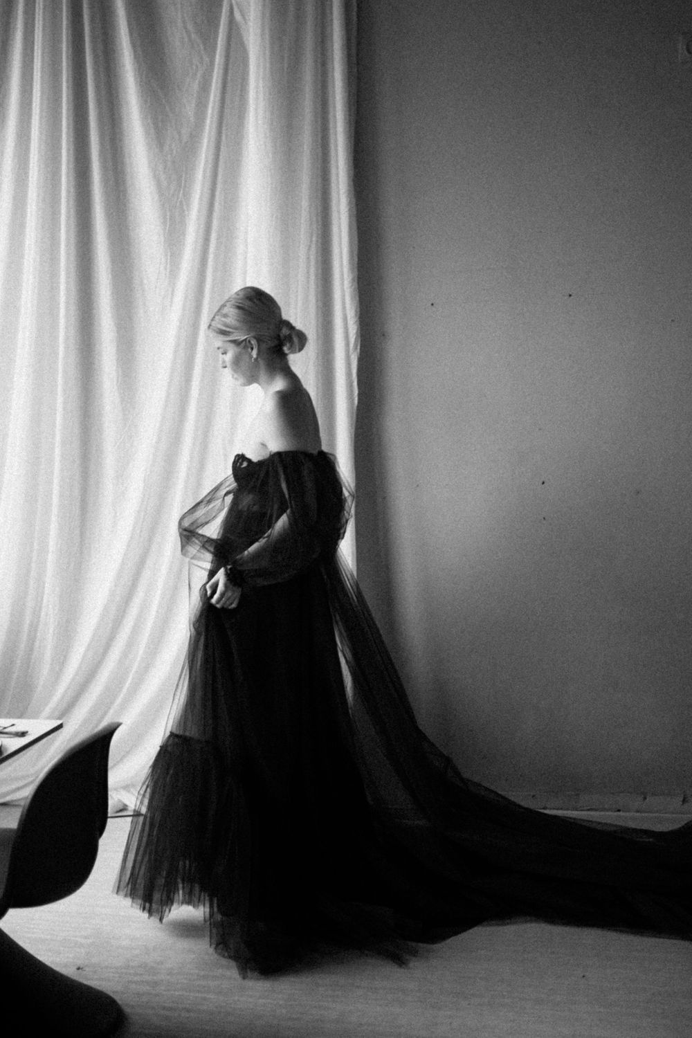 Minimalist black and white portraits showing silhouette of person in flowing dark dress.