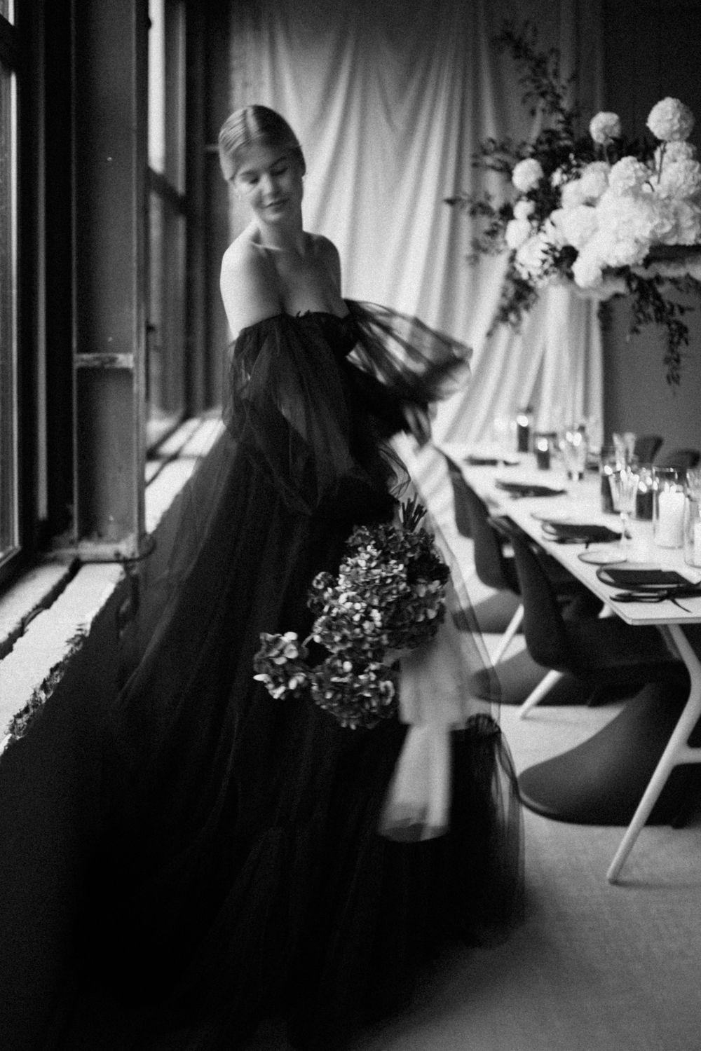 Artistic black and white sequence showing movement in a black dress near window light.