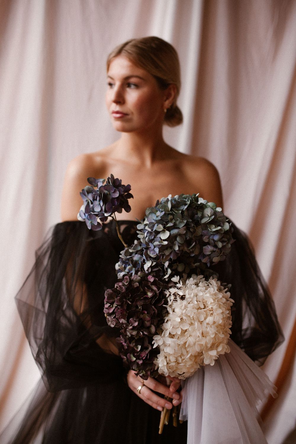 Elegant portrait featuring a black off-shoulder gown and mixed hydrangea bouquet.