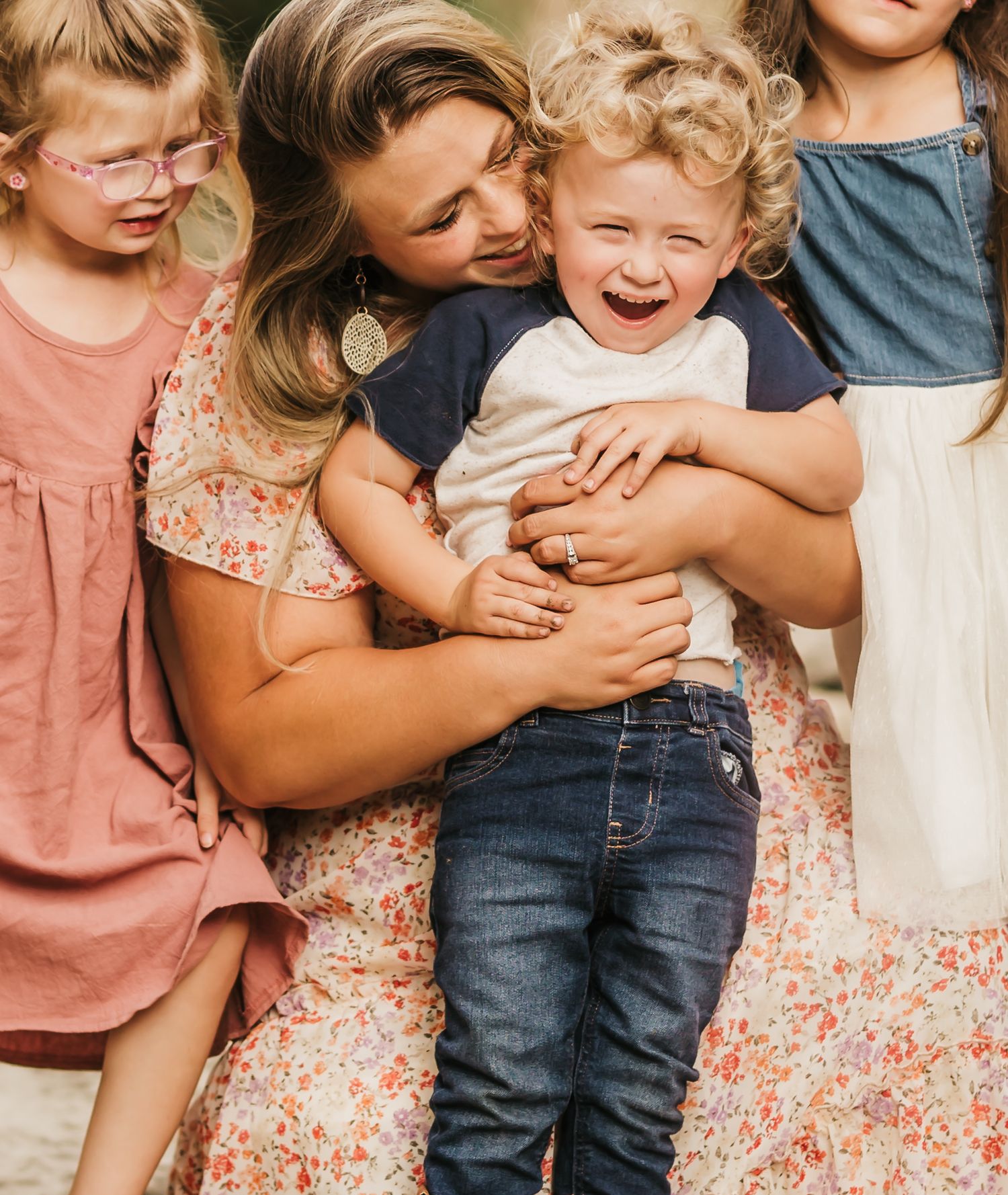 Candid moment of laughter and hugs captured in warm natural lighting.