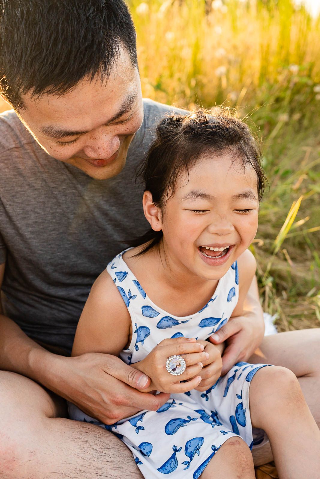 Father tickling daughter at Marymoor Park