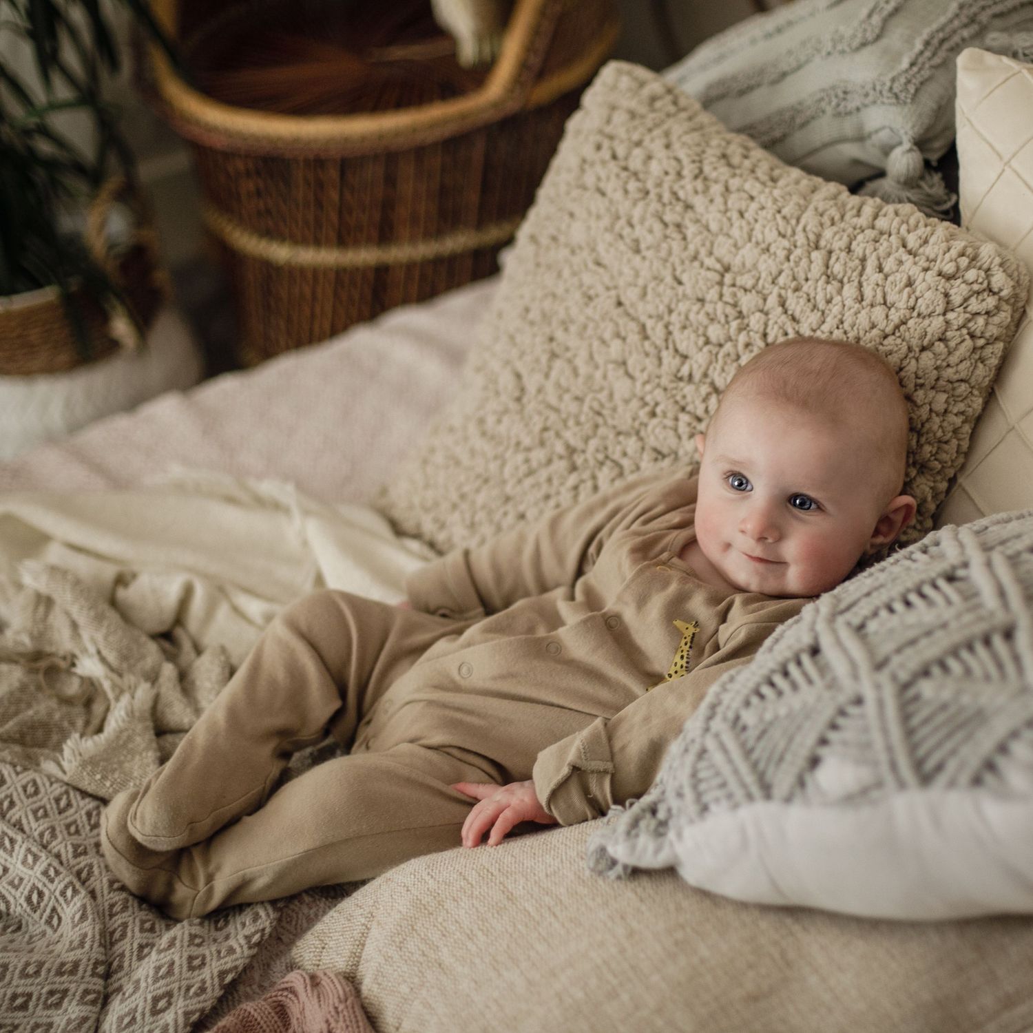 Lifestyle photography, baby sitting in textured pillows.