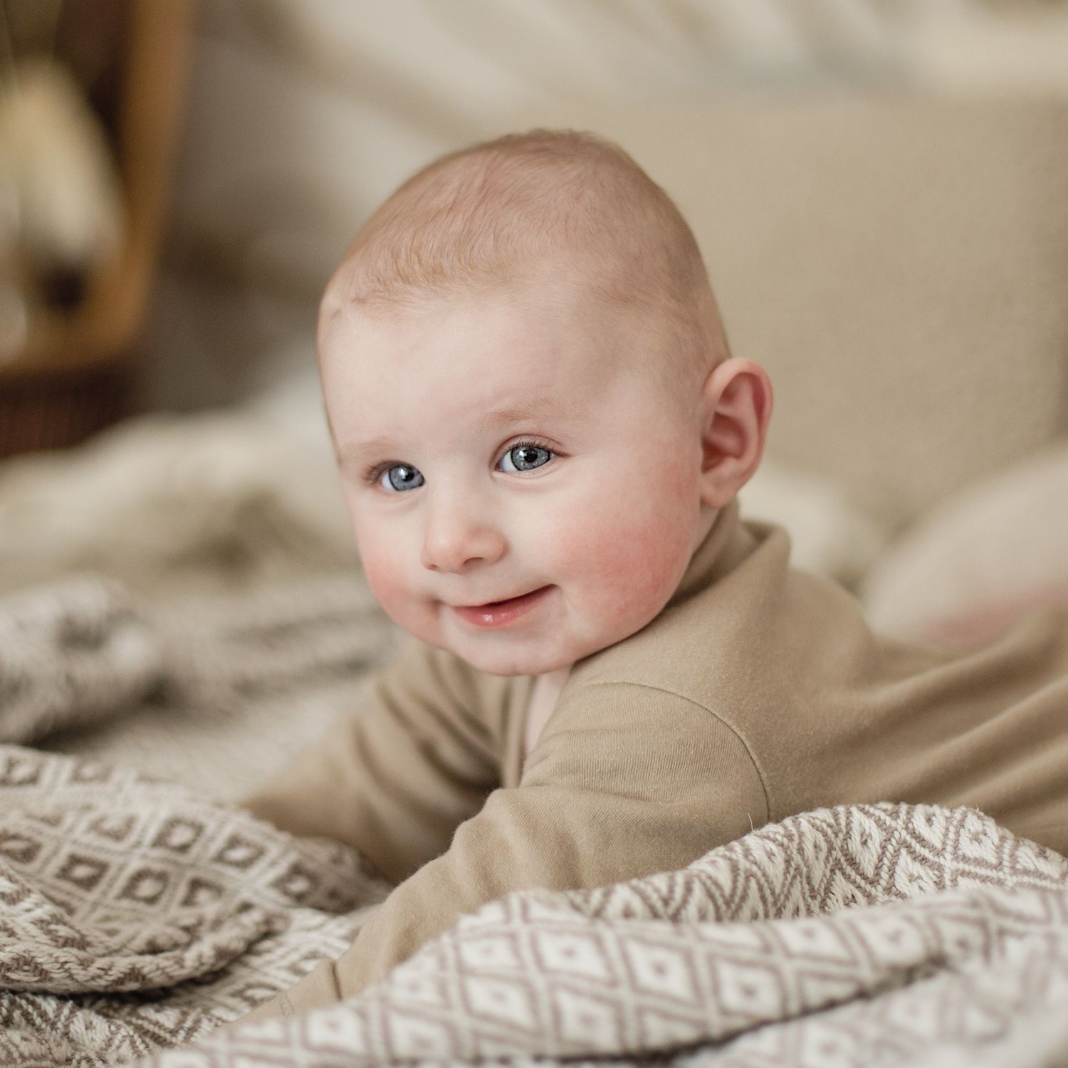 Baby smiles lying on the bed