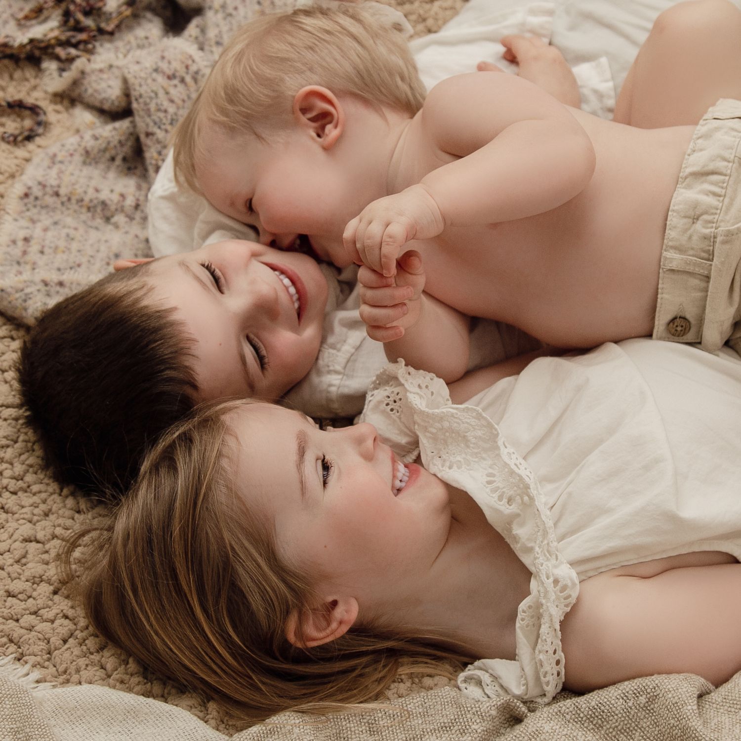 Siblings photoshoot. Kids cuddling and smiling.