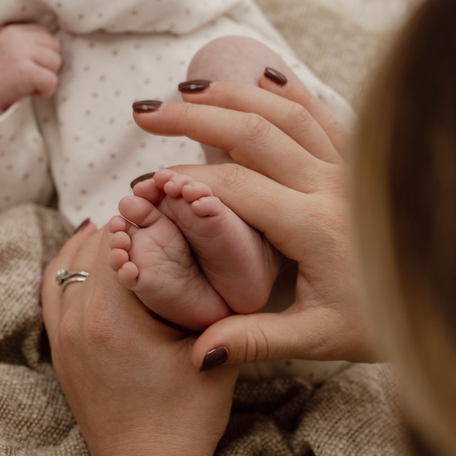 The small details, newborn photography, mum holding little feet.