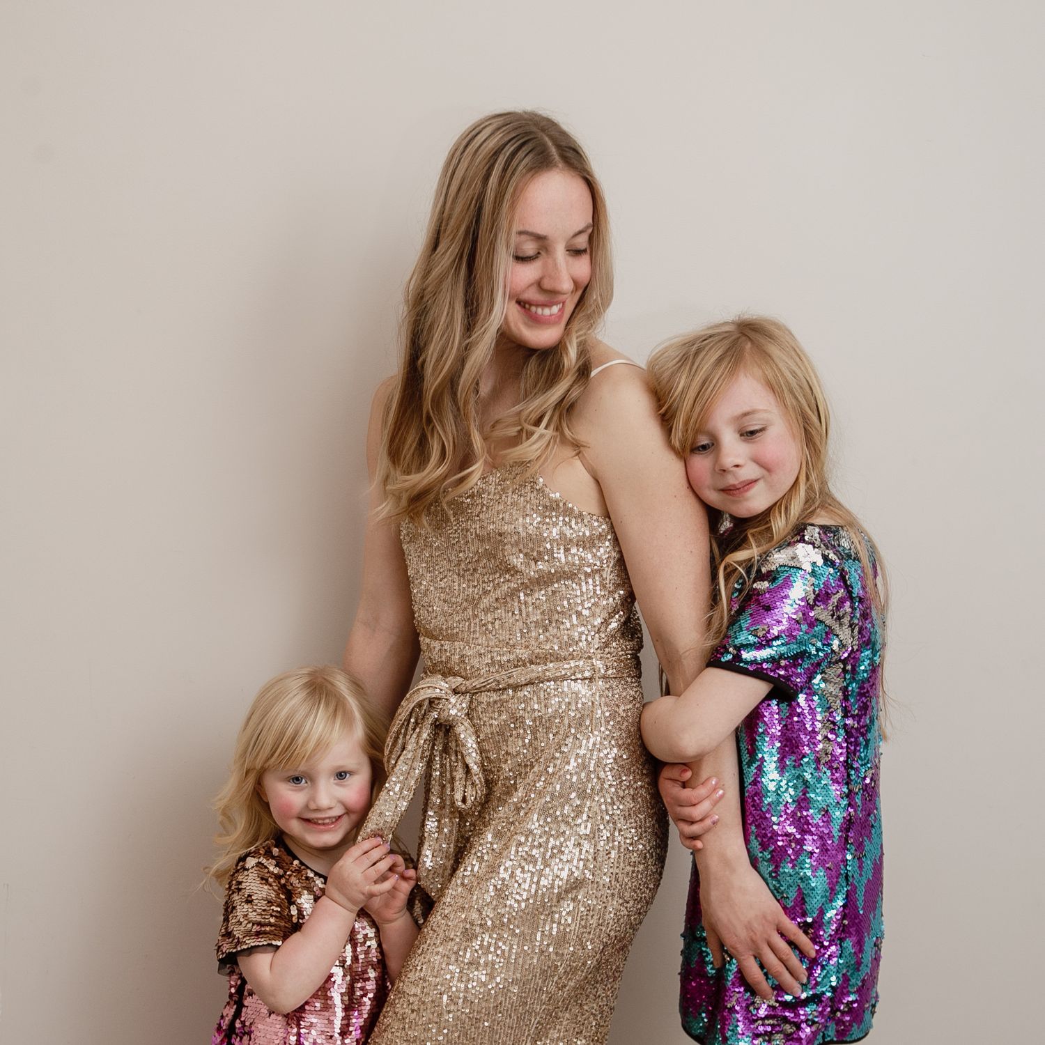 Motherhood photography. Mother and her daughters dressed in sparkles.