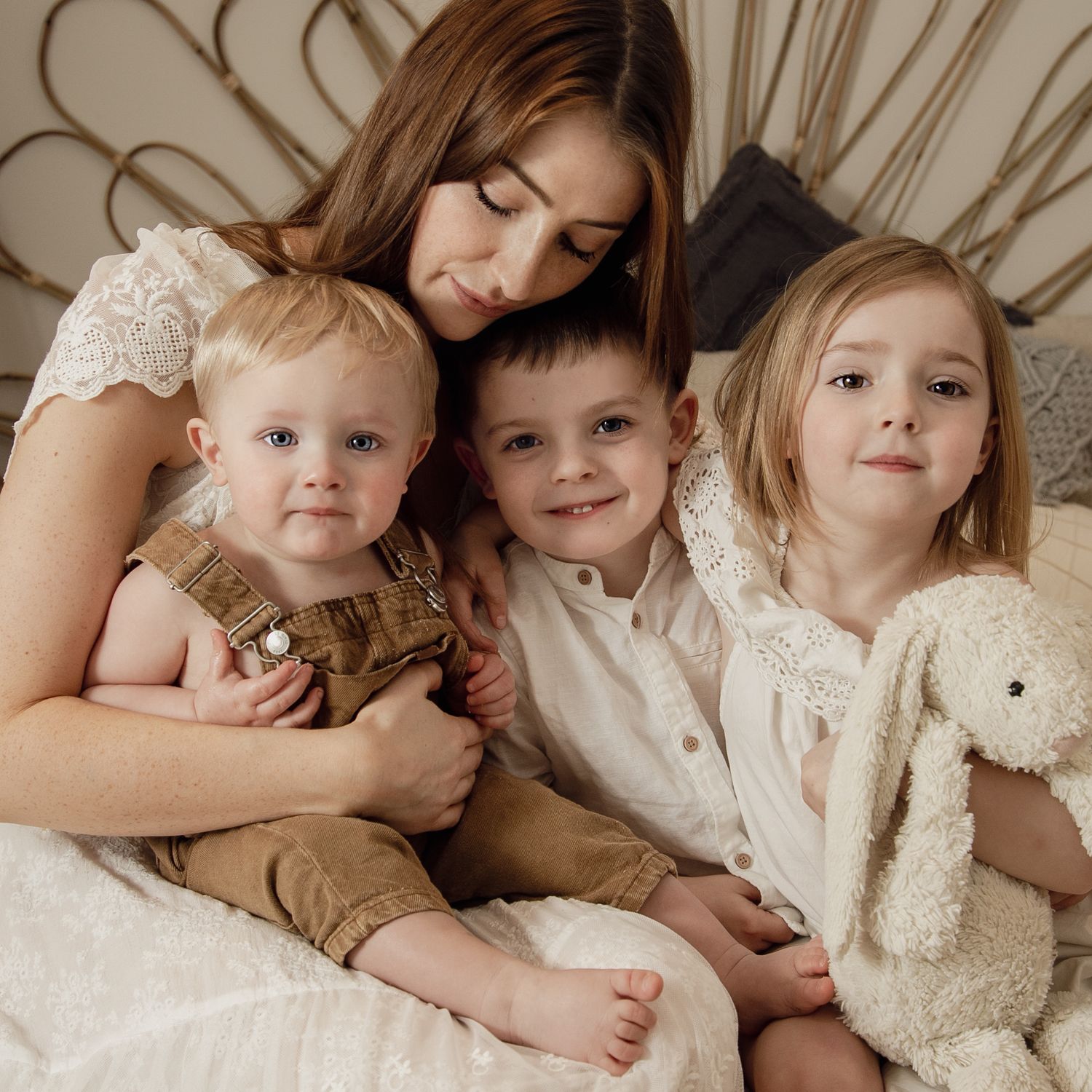 A mother holding her 3 babies for their motherhood photography session.