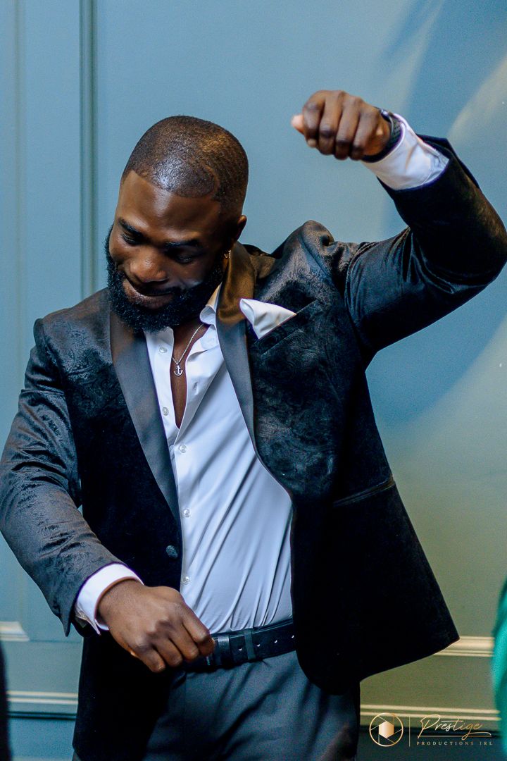 Dynamic shot of dancer in black suit jacket expressing joy through movement.