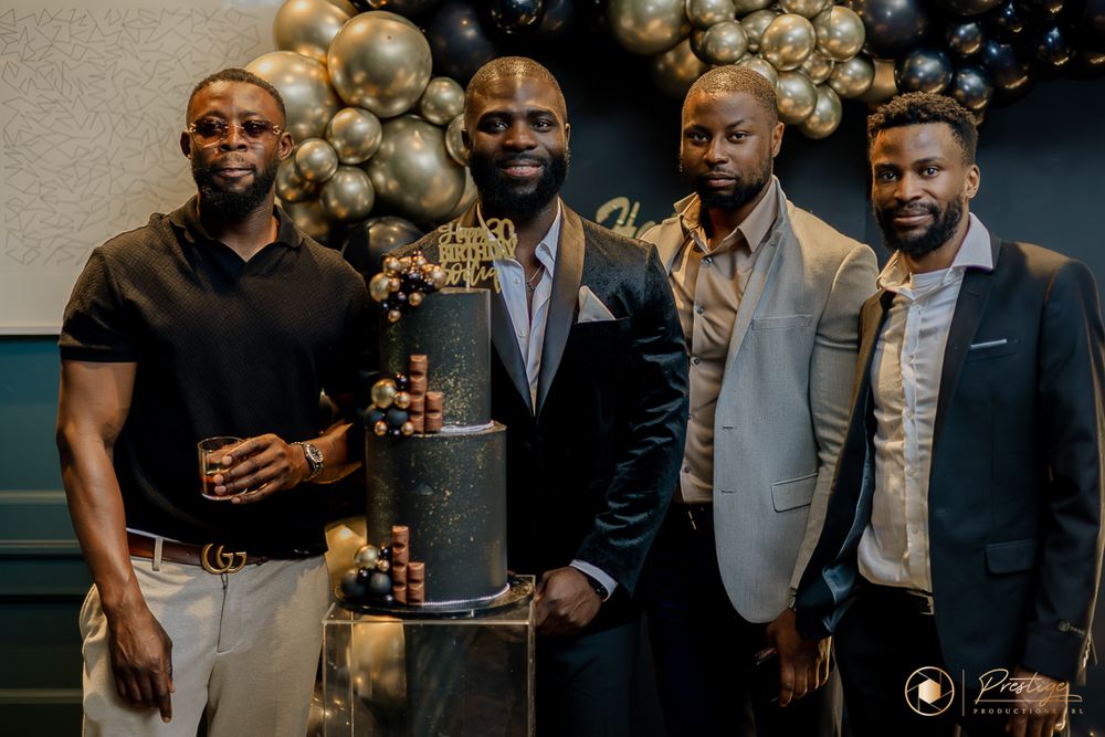 Group portrait at formal event with gold and black balloon decorations.