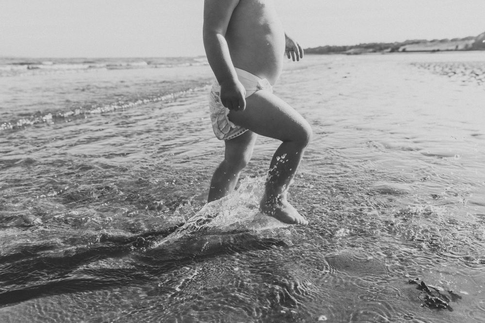 Someone splashing water at the beach captured in black and white photography.