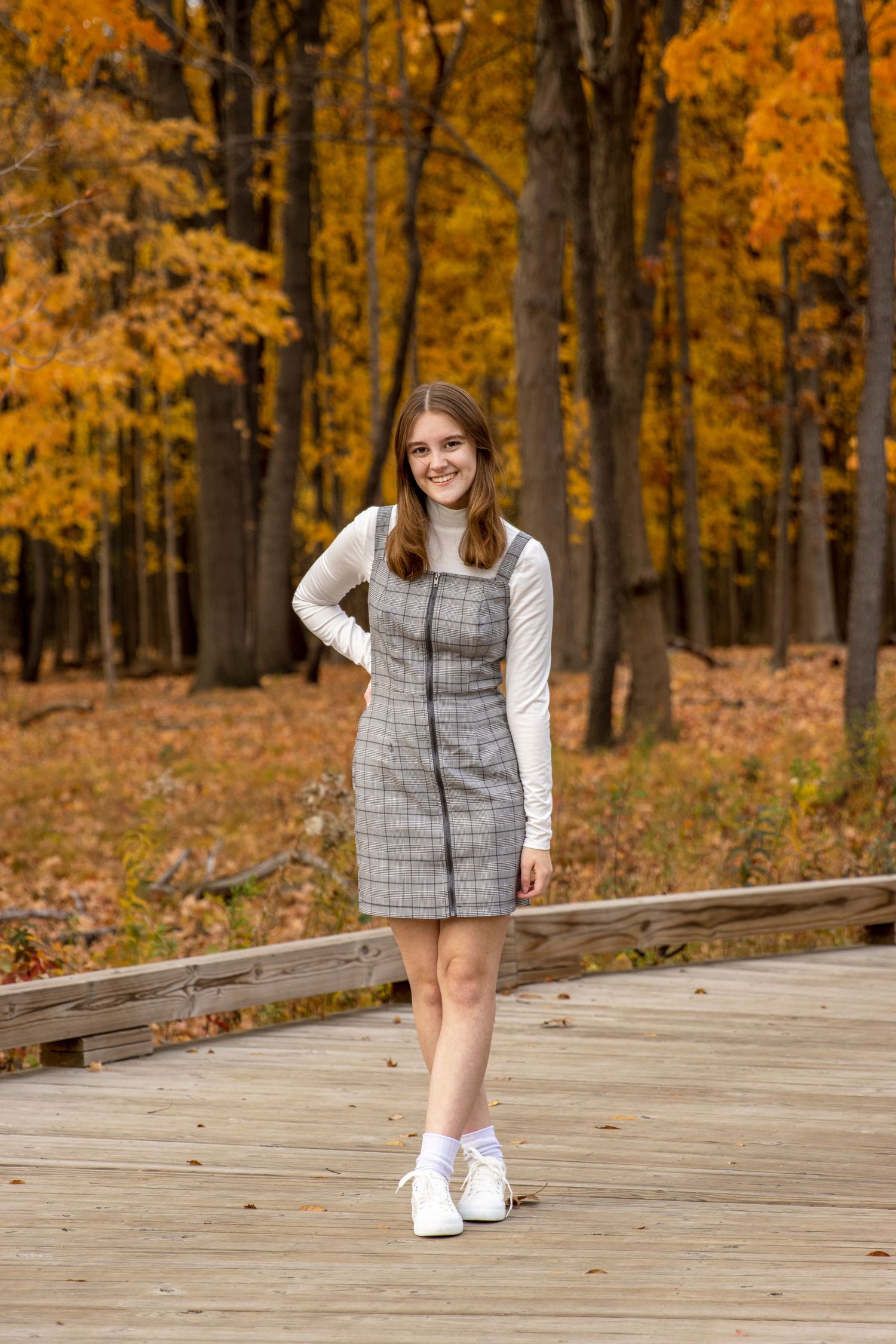 teenage girl poses for a fall photo in a grey dress in Rochester hills michigan
