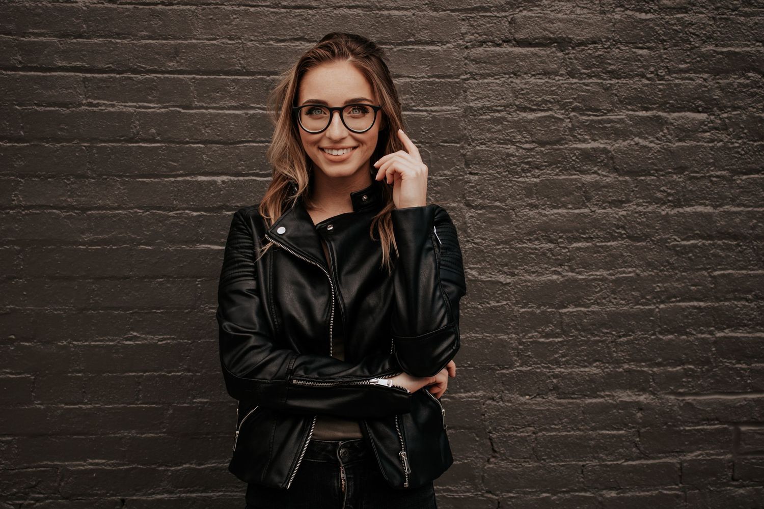 Collection of urban portraits against a dark brick wall featuring modern fashion and different poses.