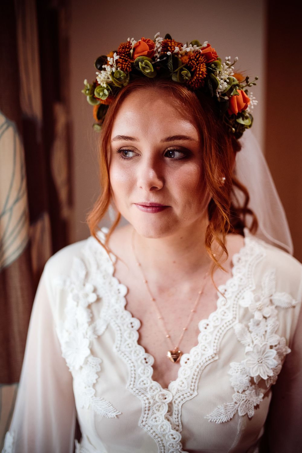 Wedding portrait showing a person wearing a floral crown and lace white dress.