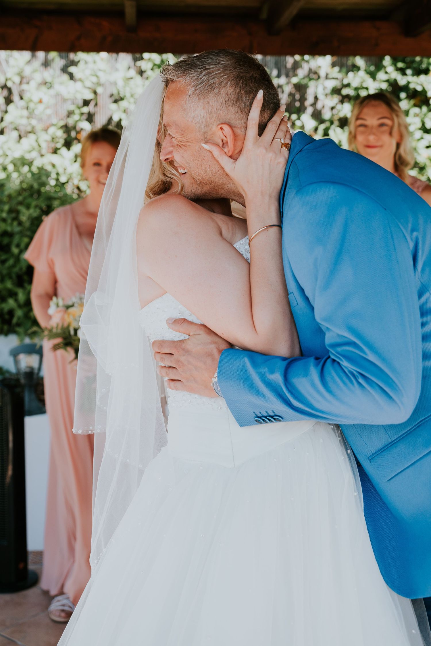 A tender moment shared during a wedding ceremony under a decorated arbor.