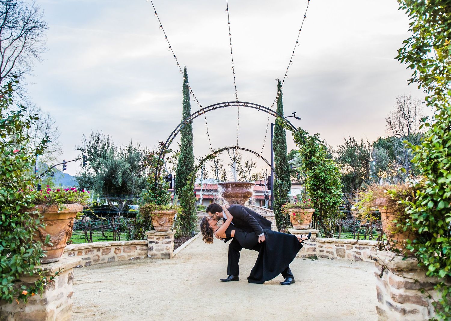 Romantic garden photography session with arch and terracotta planters.