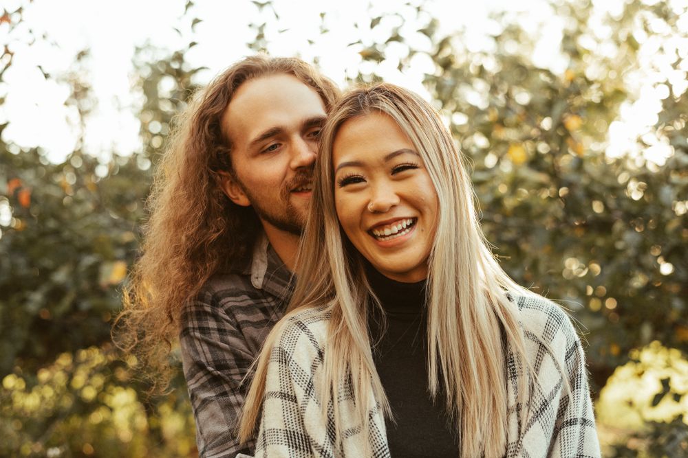 Joyful couple sharing intimate moment outdoors during golden hour.
