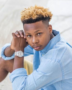 Portrait shot of person in light blue shirt wearing stylish watch.