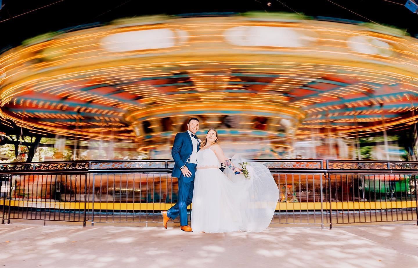 Wedding couple posing in front of a kennywood carousel. Pittsburgh wedding Photographer