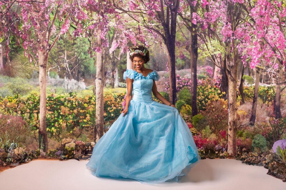Blue ballgown photographed in garden setting with blooming pink trees.