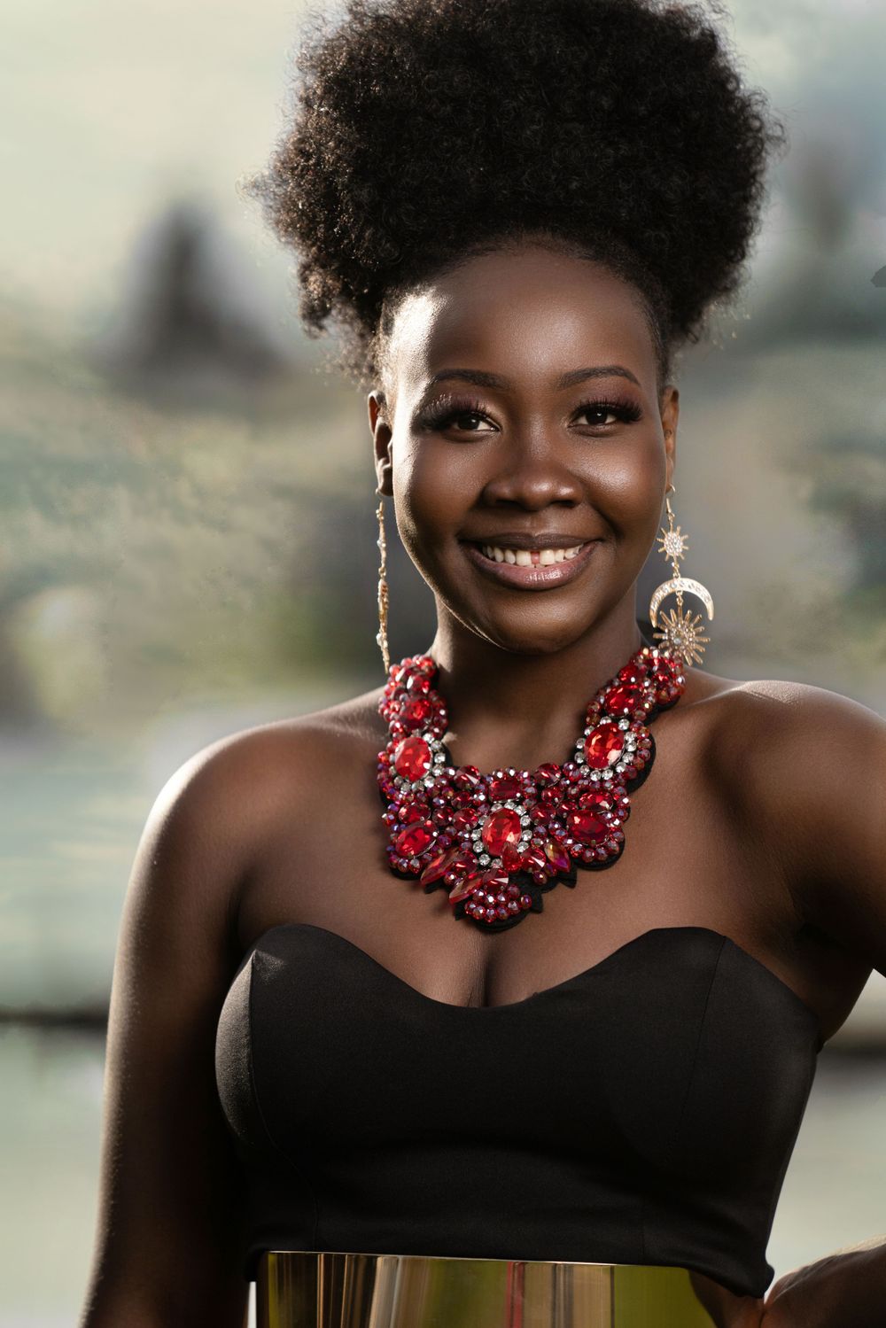 Elegant portrait featuring a black dress and statement red crystal necklace.