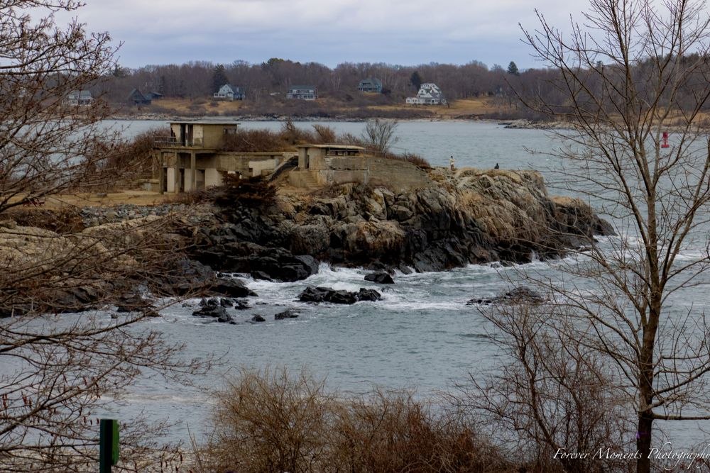 Rocky coastal landscape with houses overlooking the ocean.