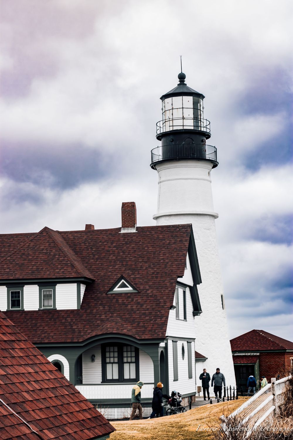 Historic Portland Head Light lighthouse with red-roofed keeper's house in Maine.