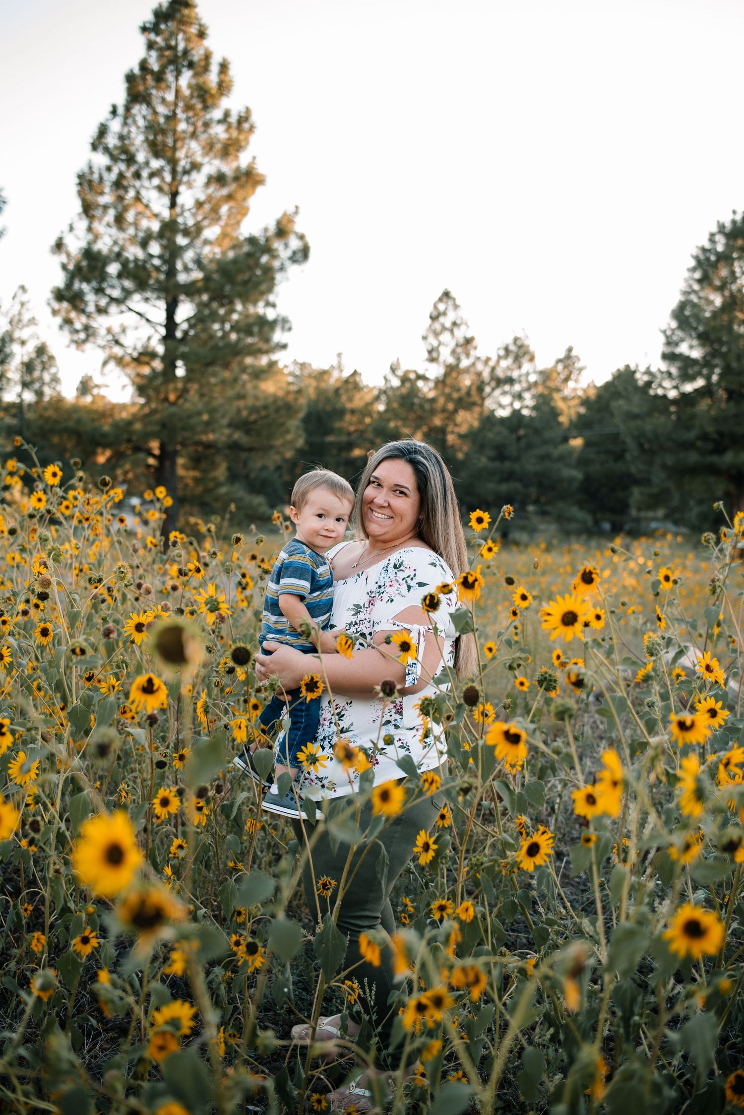 A tender moment captured in a field of wild sunflowers at sunset.