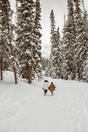 Photo of two children running in the winter by Kristy Baker Photography, a local Steamboat Springs, Colorado photographer.