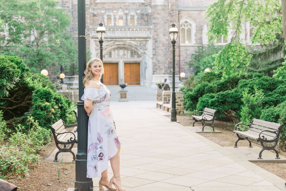 Two people pose together near benches outside a stone building entrance.