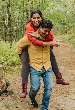 A couple smiles and laughs together during a family portrait session in Brunswick, Maine.