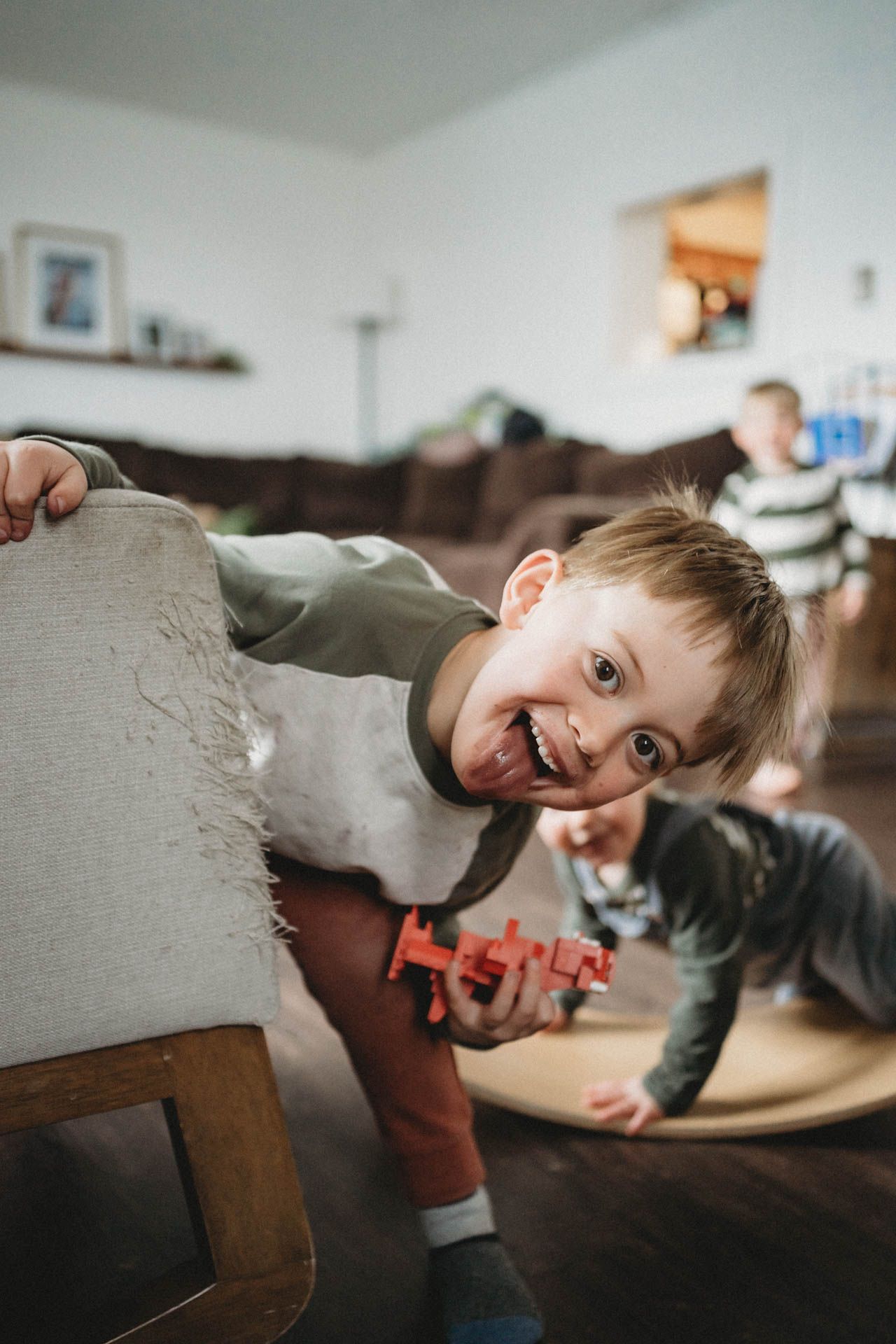 Playful moment on wooden furniture during indoor family activity.