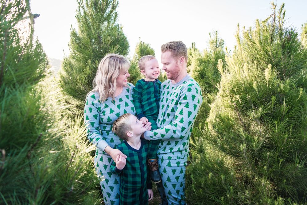 Photo of a family standing in Christmas trees at Peltzer Pines Christmas Tree Farm in Orange County, CA