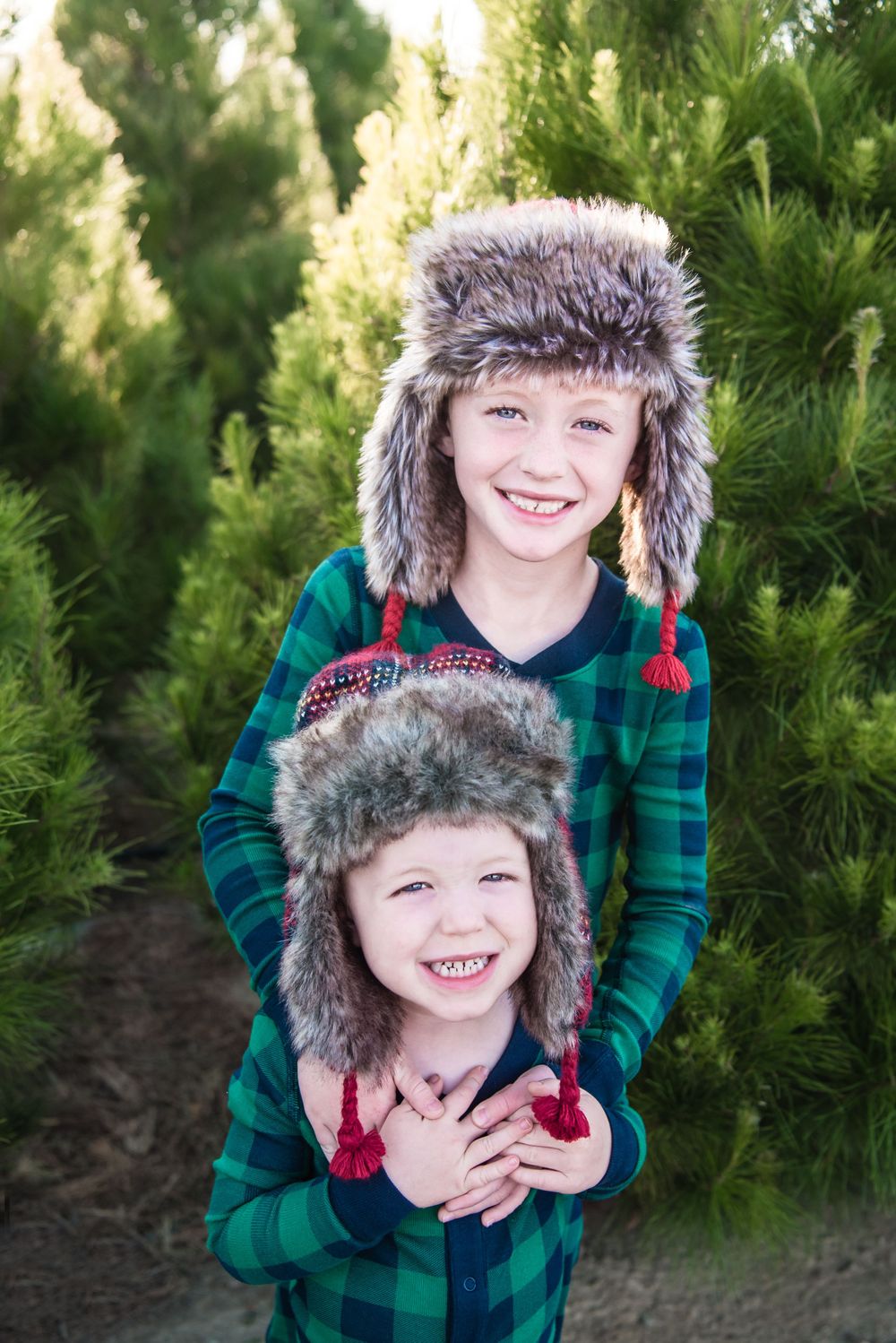 Photo of two brothers standing in Christmas Trees at Peltzer Pines Christmas Tree Farm in Orange County, CA