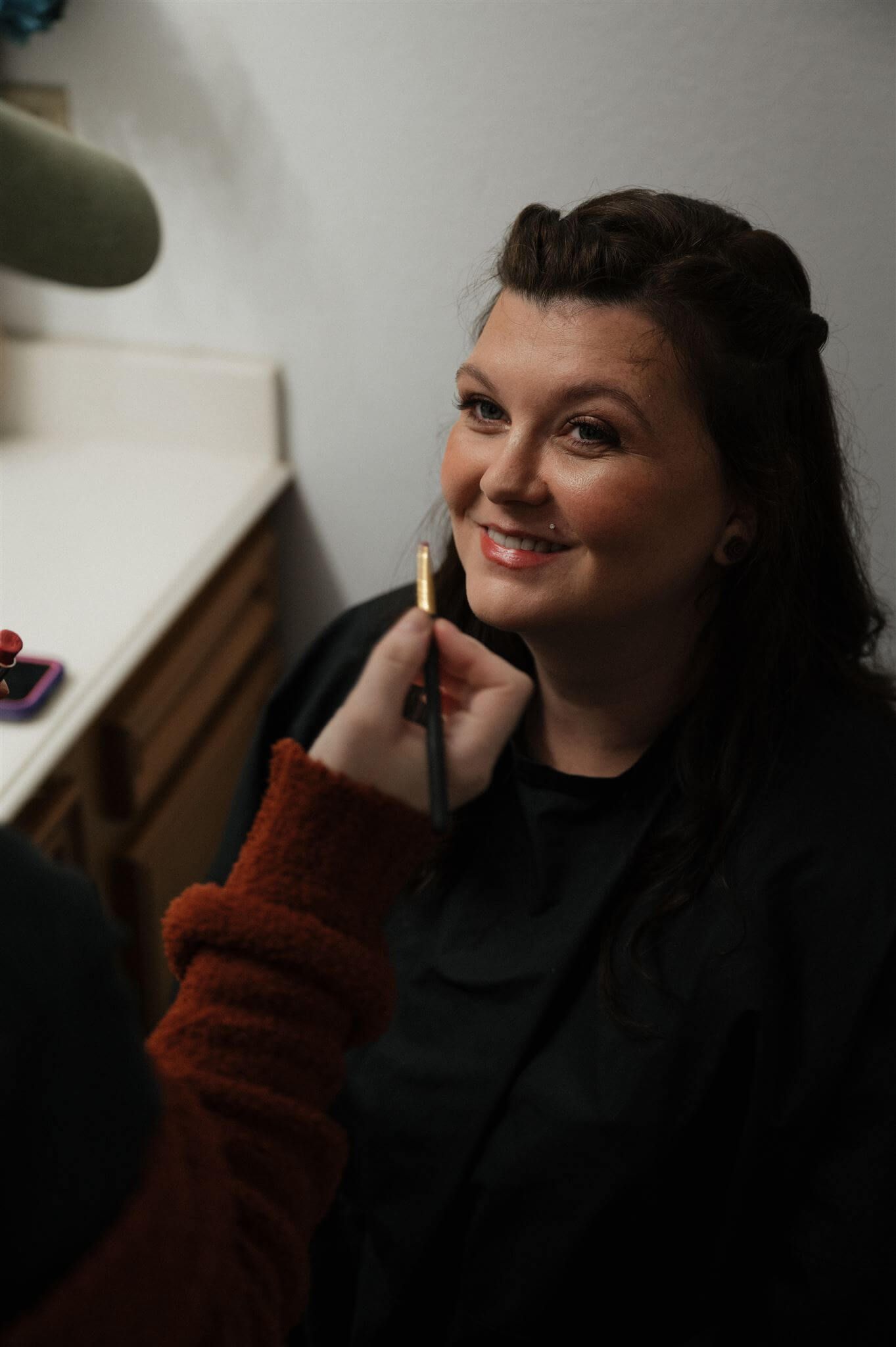 Someone getting ready backstage while having makeup applied.