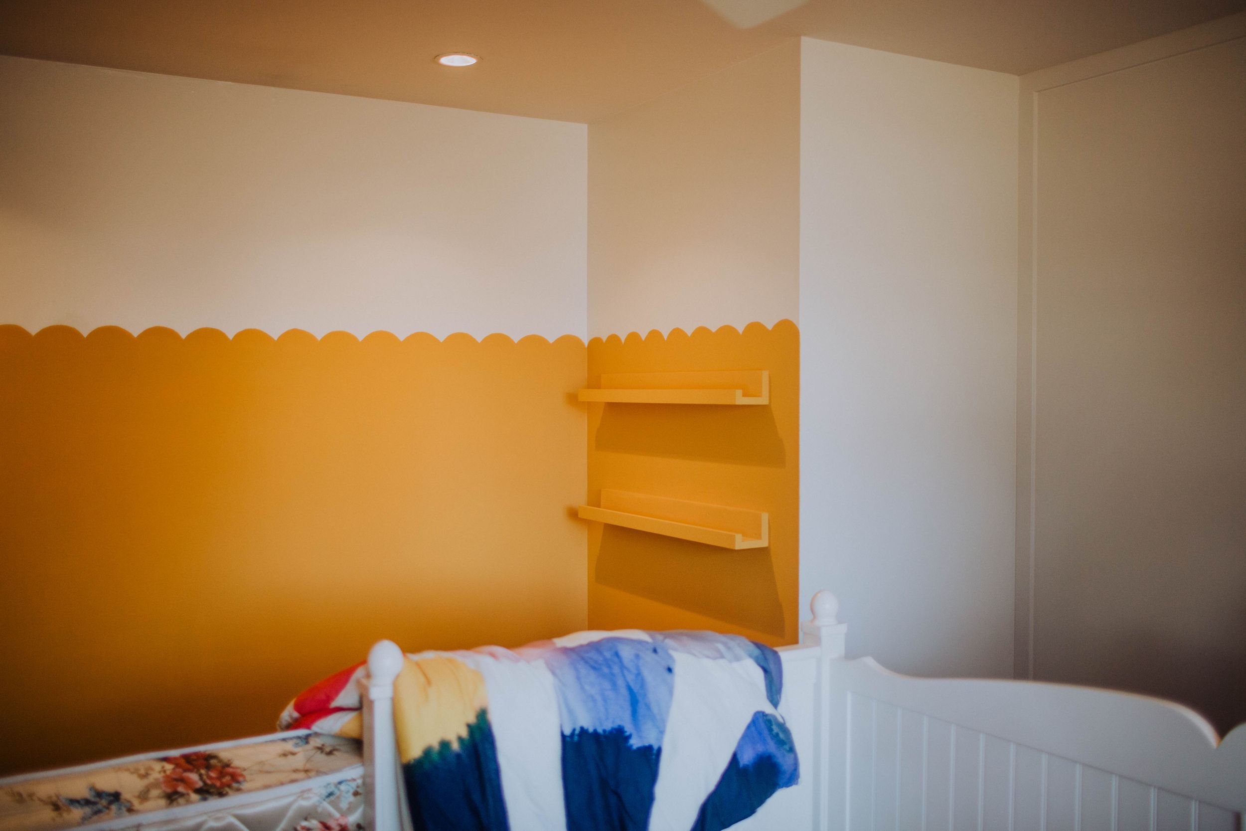 Bedroom with orange accent wall and white trim during renovation process.