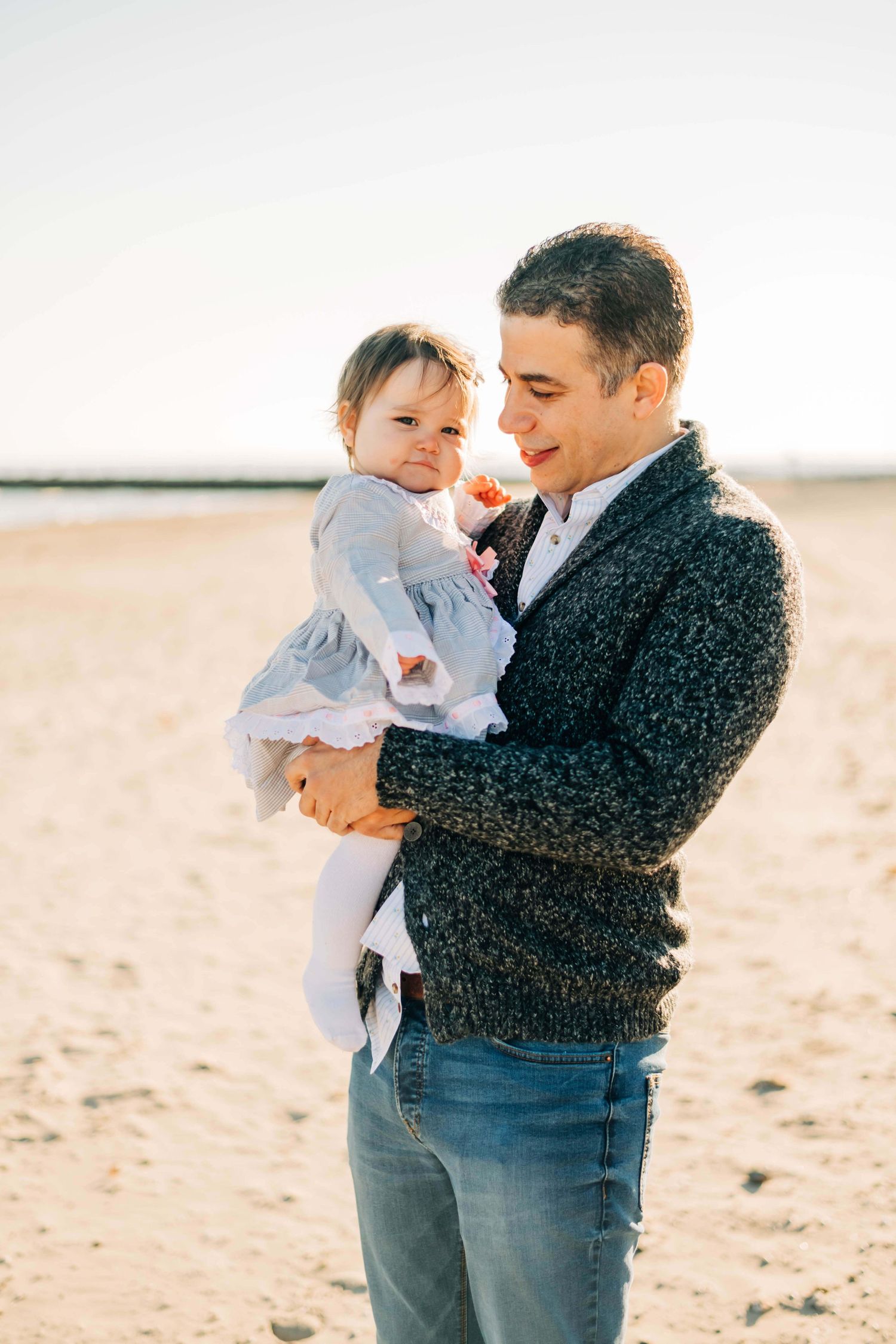 father holding his baby girl at a beach