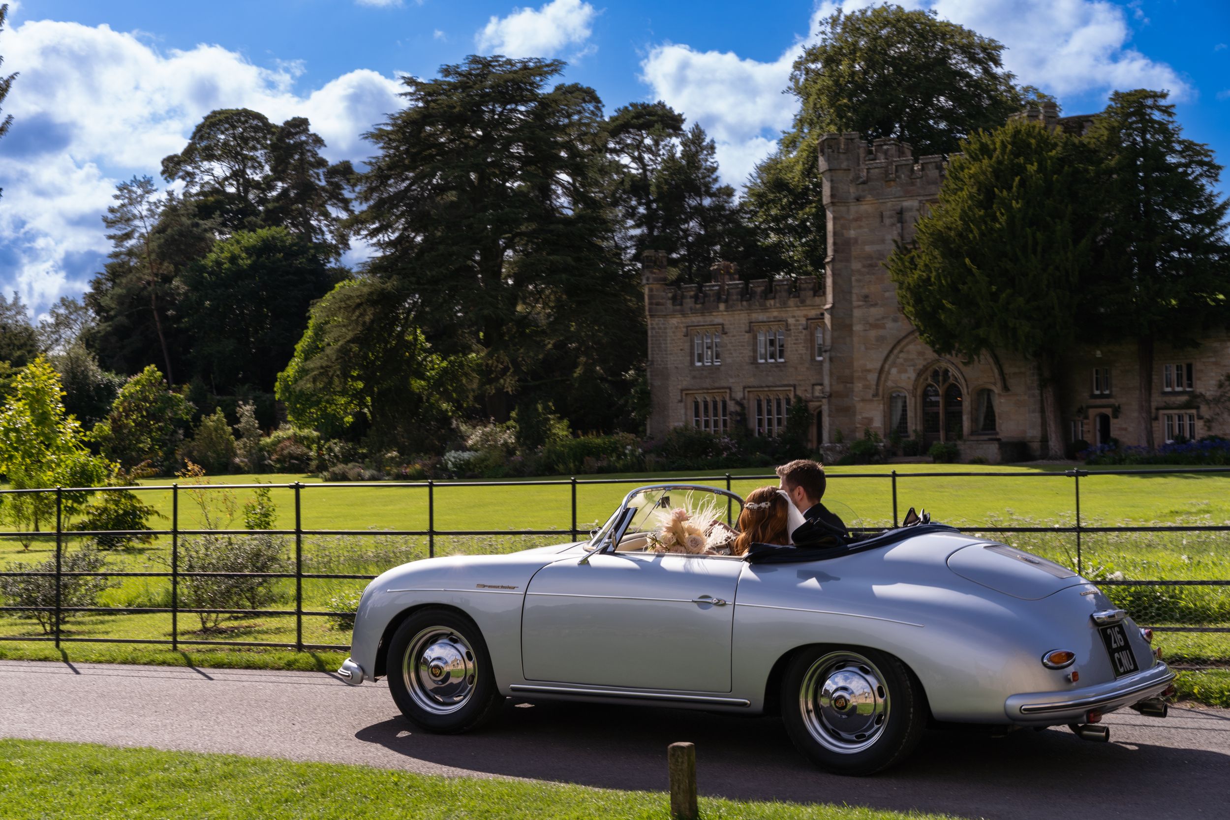 bride and groom driving away past bolton abbey on their wedding day by wedding photographer in Doncaster.