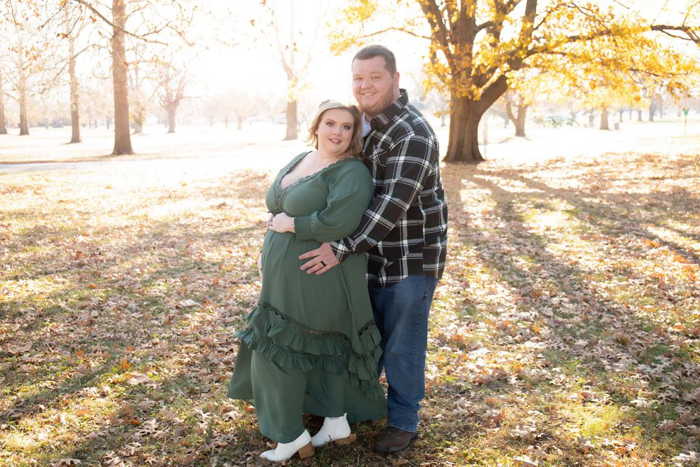 Two people embracing outdoors in autumn with golden leaves and sunlight streaming through trees.