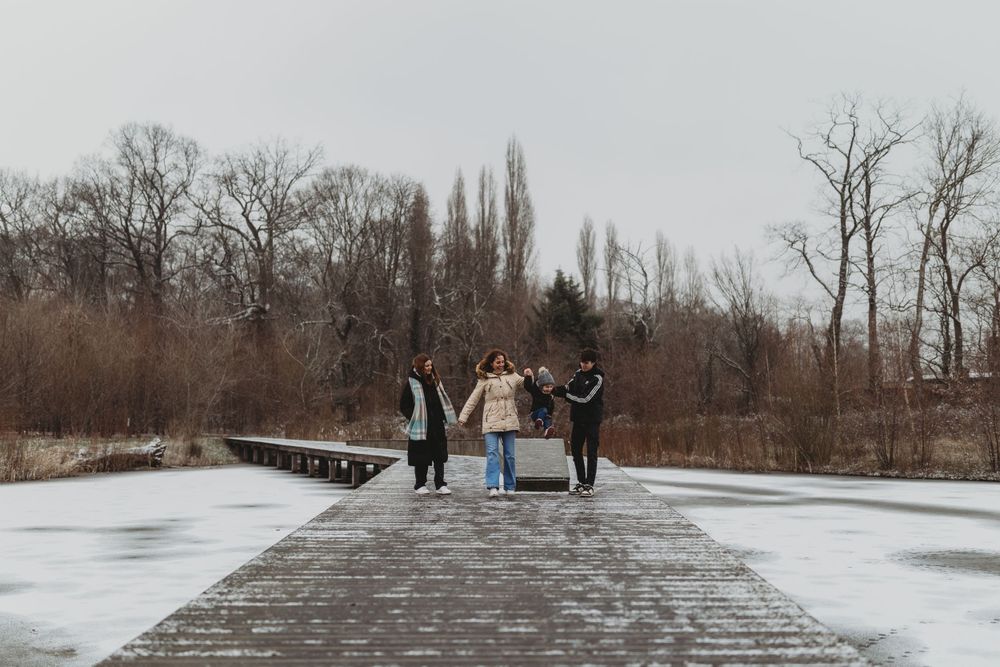 Small group standing on a wooden pier during a cold winter day.