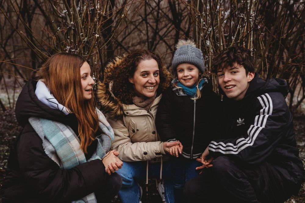 Friends sitting close together outdoors sharing joyful laughter in winter.