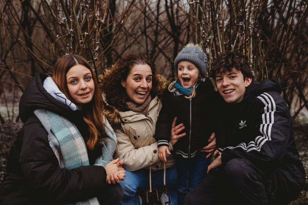 Small group laughing together outdoors during winter weather.
