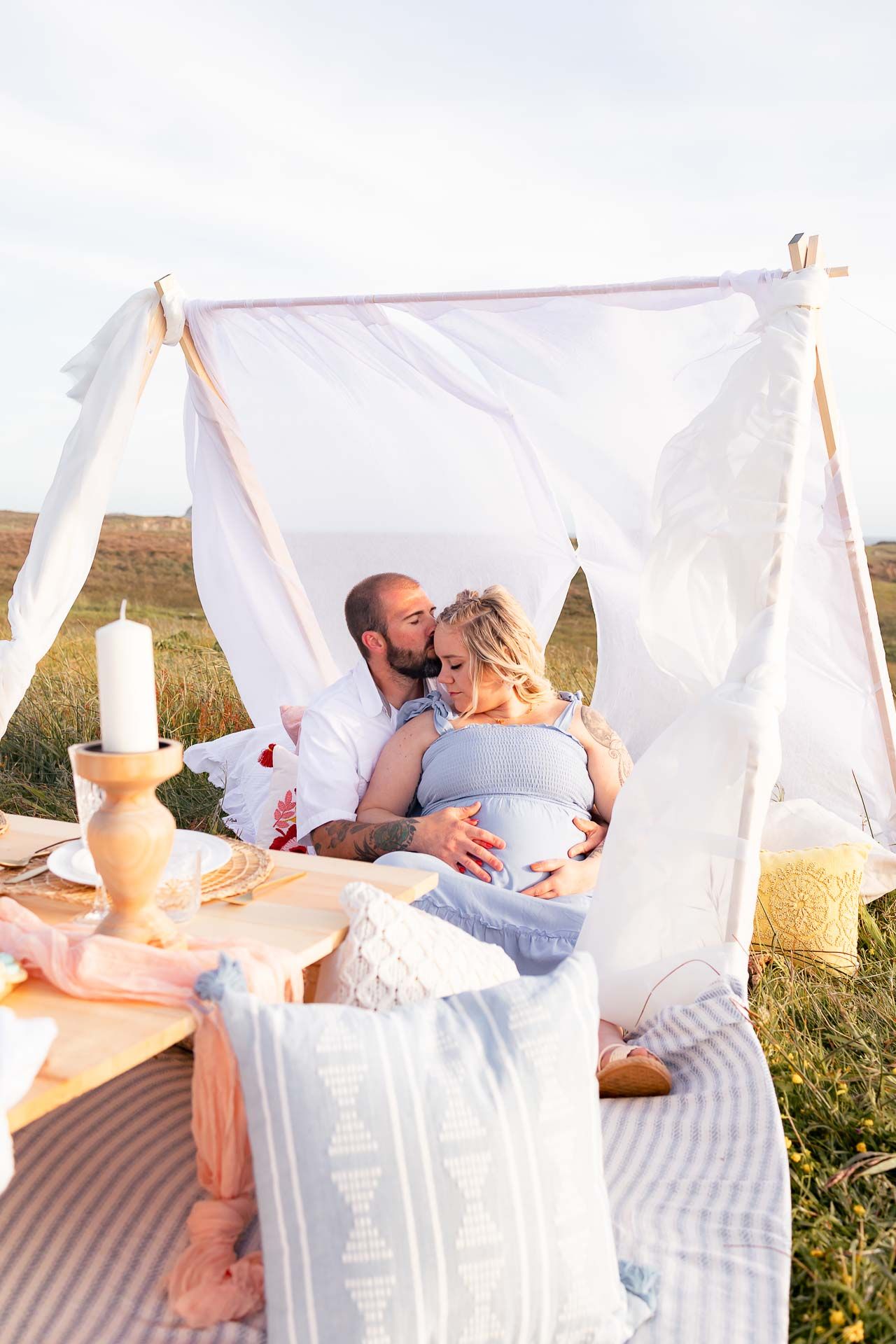 Maternity couple snuggled together for a picnic on the Southern Coast of Oregon