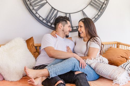 engagement couple cuddling on couch