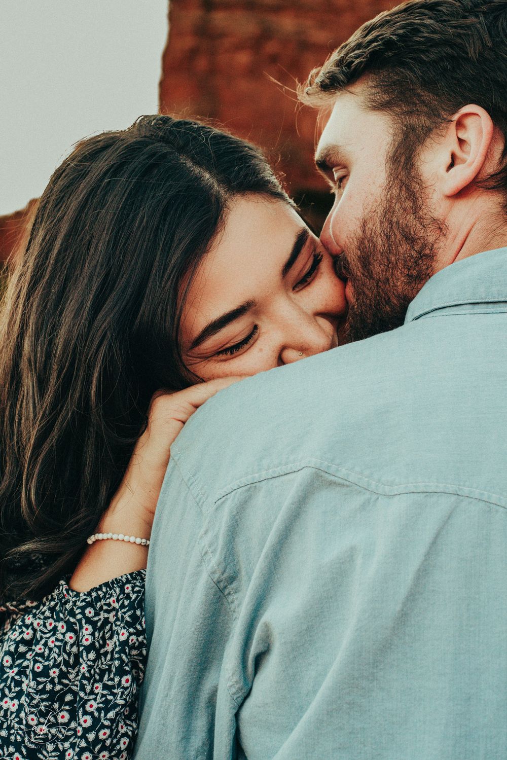 Close-up of tender embrace between couple during romantic moment.