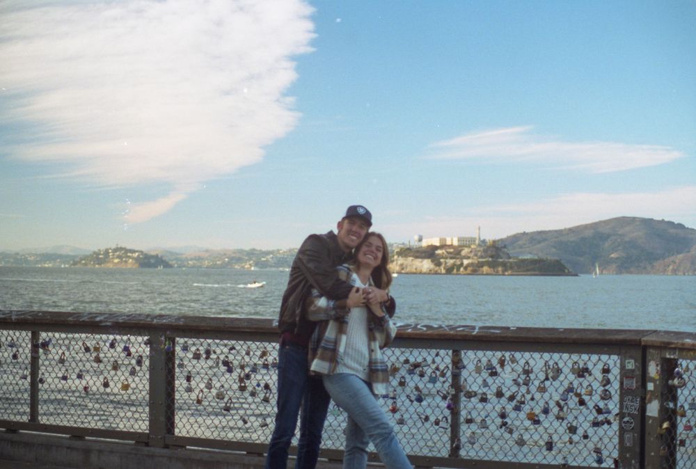 Romantic moment on pier with San Francisco Bay and Alcatraz Island in background.