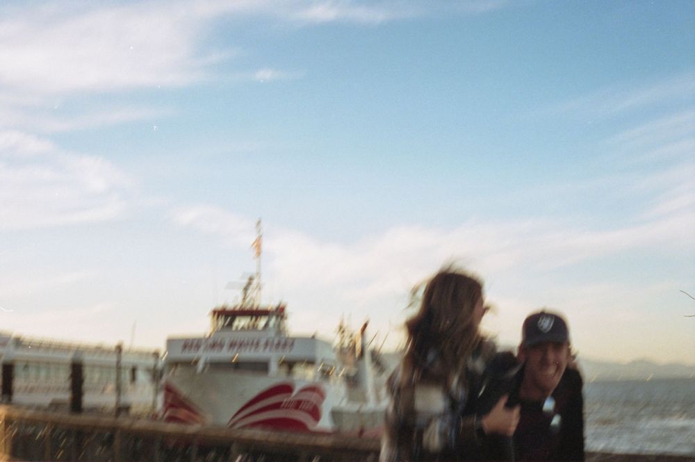 Blurred photo of people by a ferry boat at San Francisco's waterfront during daytime.