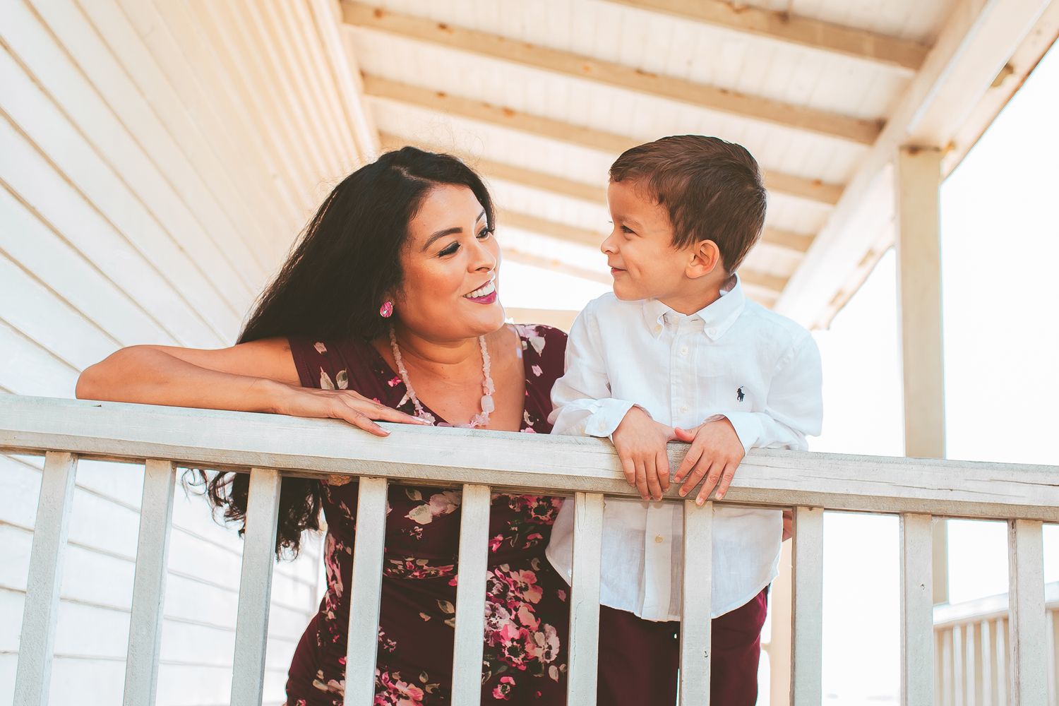 Parent and child sharing a tender moment on a white porch railing.