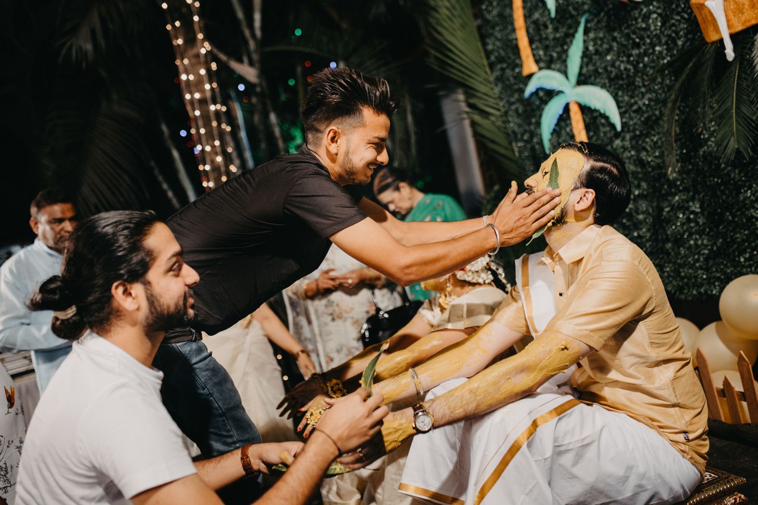 Colorful outdoor celebration with drinks being poured and splashed in festive lighting.